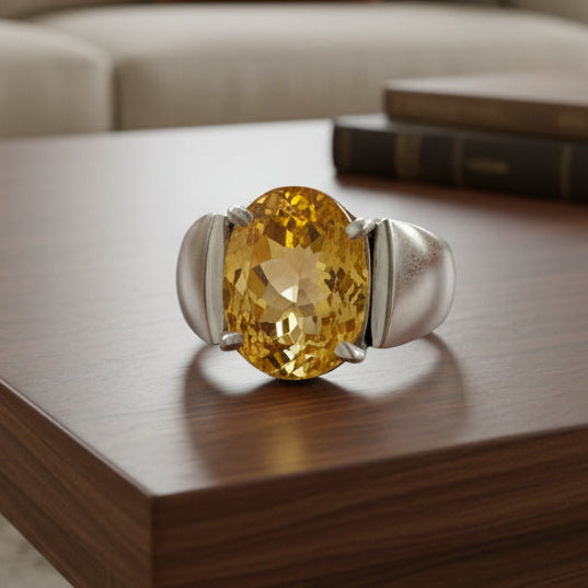 Ring with a yellow citrine gemstone on a light gray background