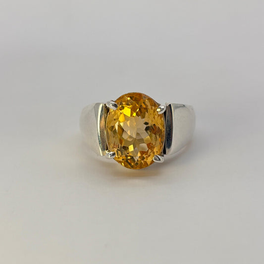 Ring with a yellow citrine gemstone on a light gray background