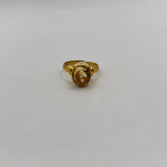 Gold ring with a citrine gemstone on a light gray background