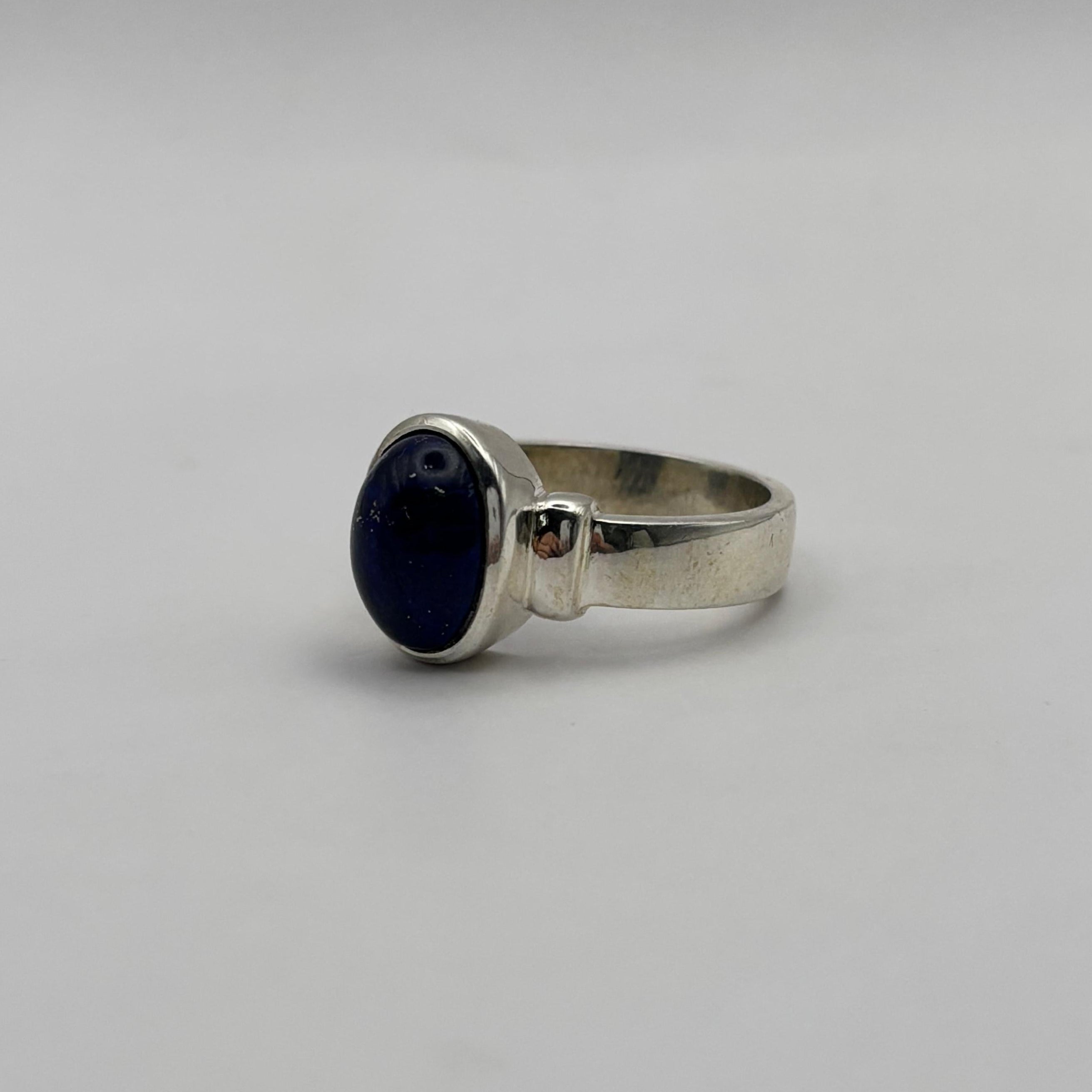 Silver ring with a lapiz lazuli gemstone on a gray background