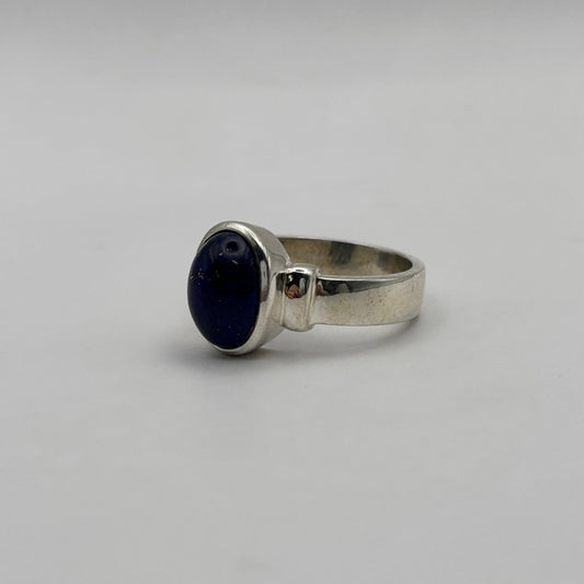 Silver ring with a lapiz lazuli gemstone on a gray background